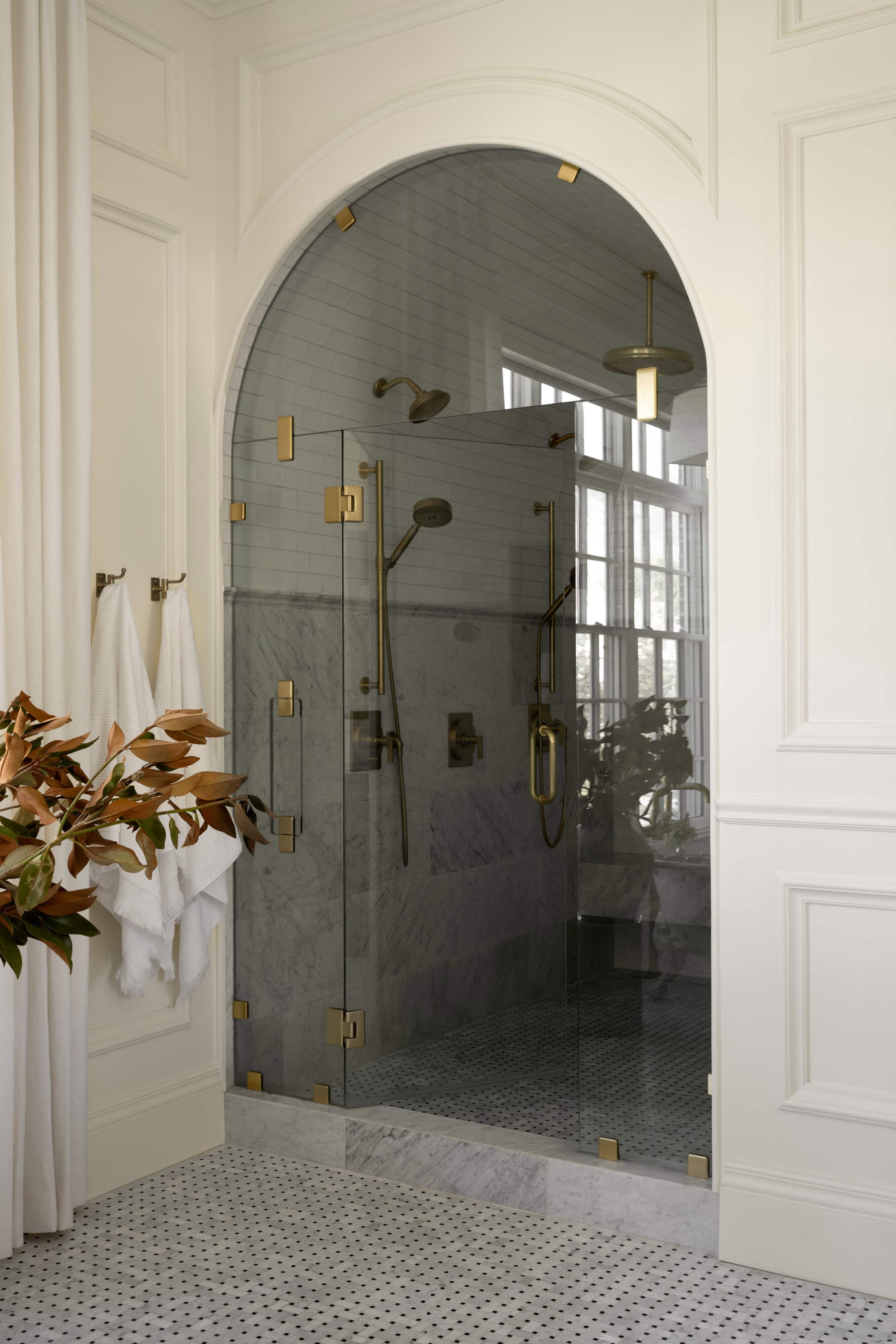 A glass shower with a glass door, by McGee & Co.