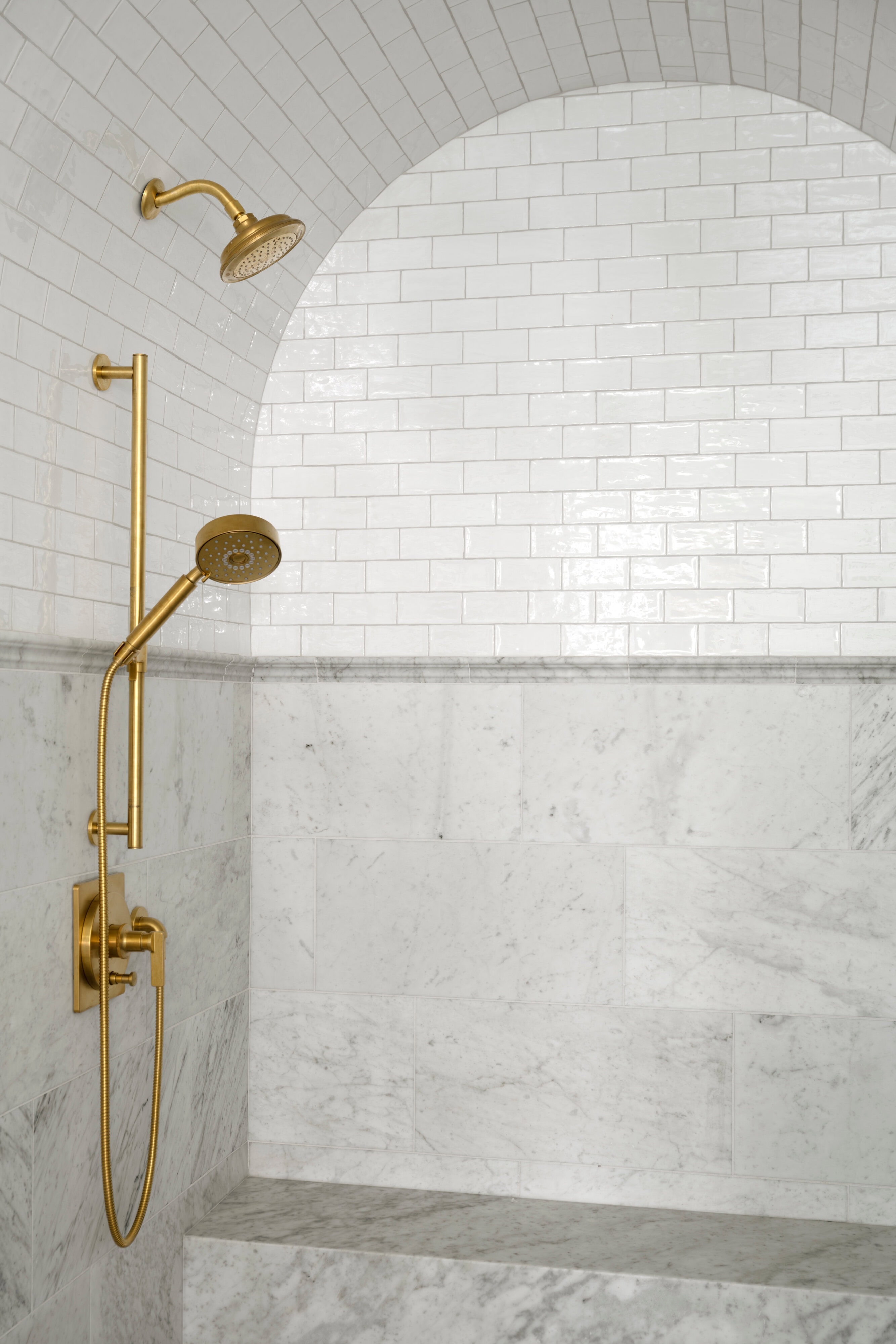 A shower head in a bathroom, by McGee & Co.