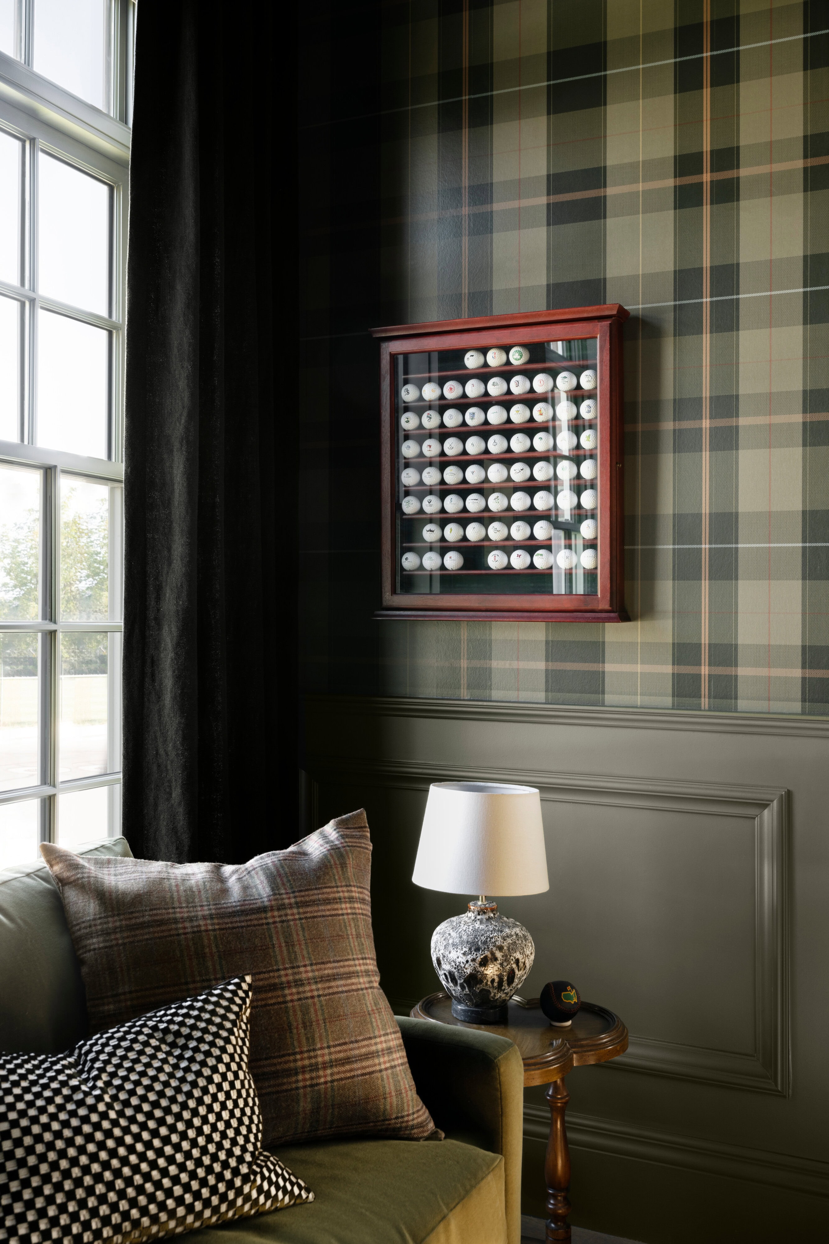 A room with a plaid wallpaper and a framed picture of golf balls, by McGee & Co.