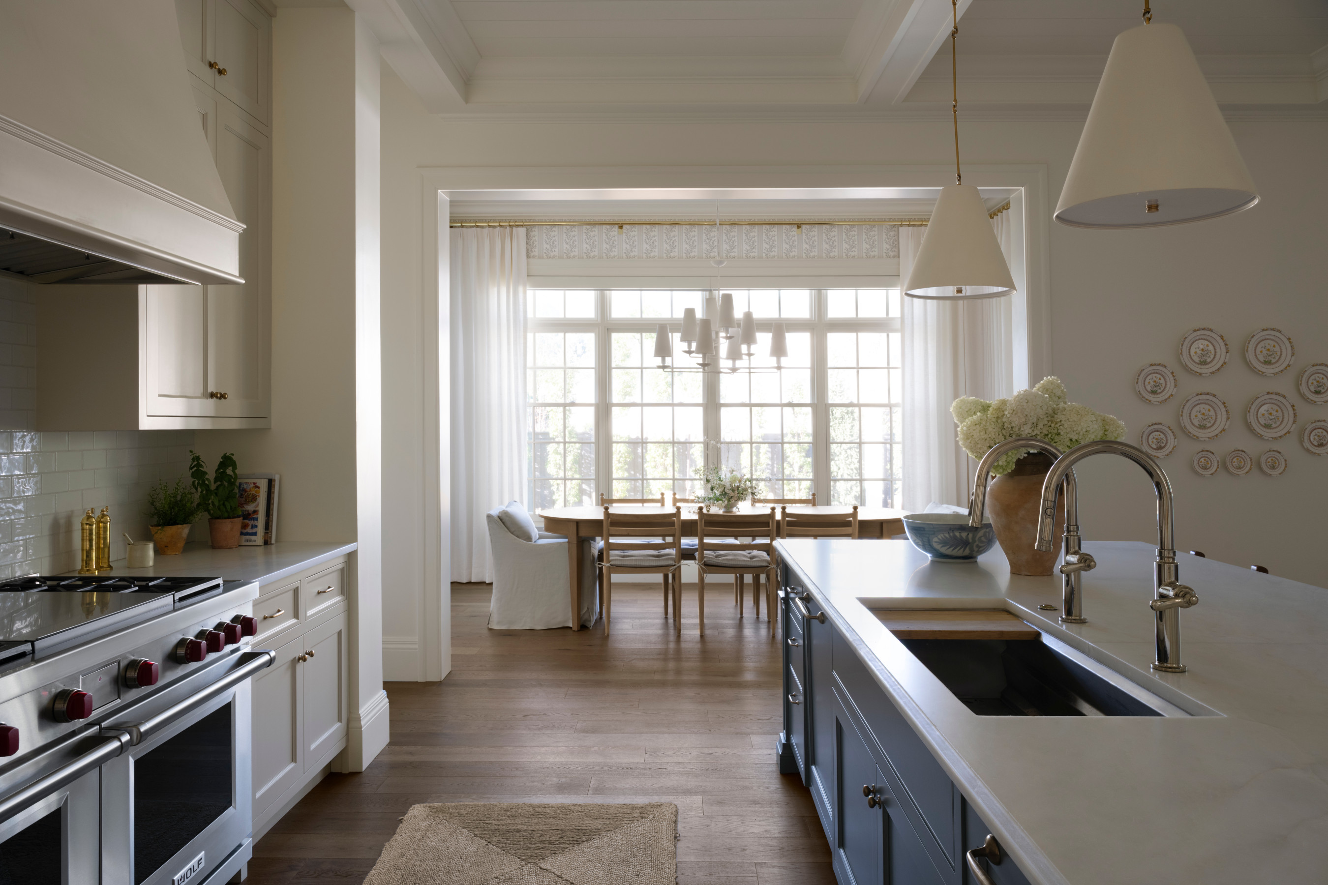 A kitchen with a dining table and chairs, by McGee & Co.